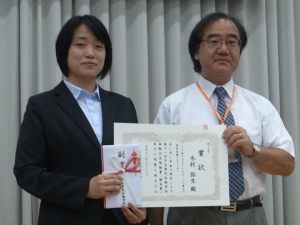 木村弥生准教授と賞状の写真